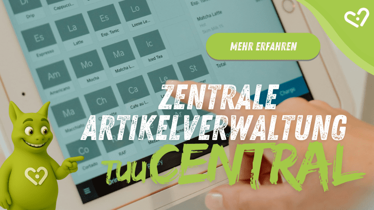 Hand bestellt über digitales Display-Menü; Tuutuu zeigt auf den Text: 'Zentrale Artikelverwaltung – tuuCENTRAL'.
