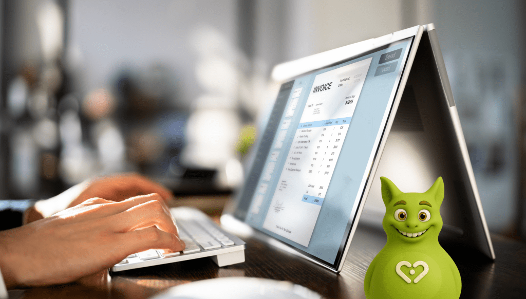 Person working on digital invoice using touchscreen laptop with Tuutuu mascot in the foreground.