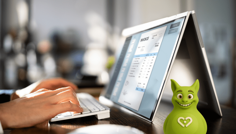 Person erstellt digitale Rechnung auf Touchscreen-Laptop mit Tuutuu-Maskottchen im Vordergrund.